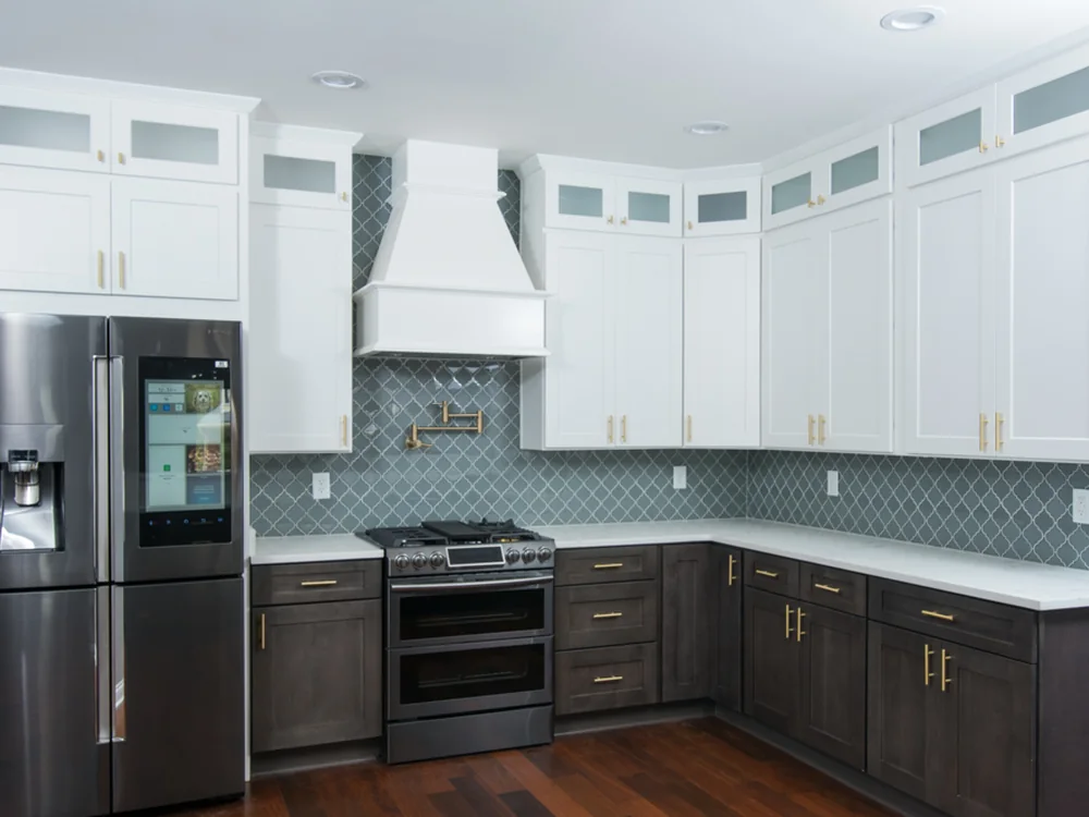 Finished kitchen remodel with two-tone cabinets and tile backsplash